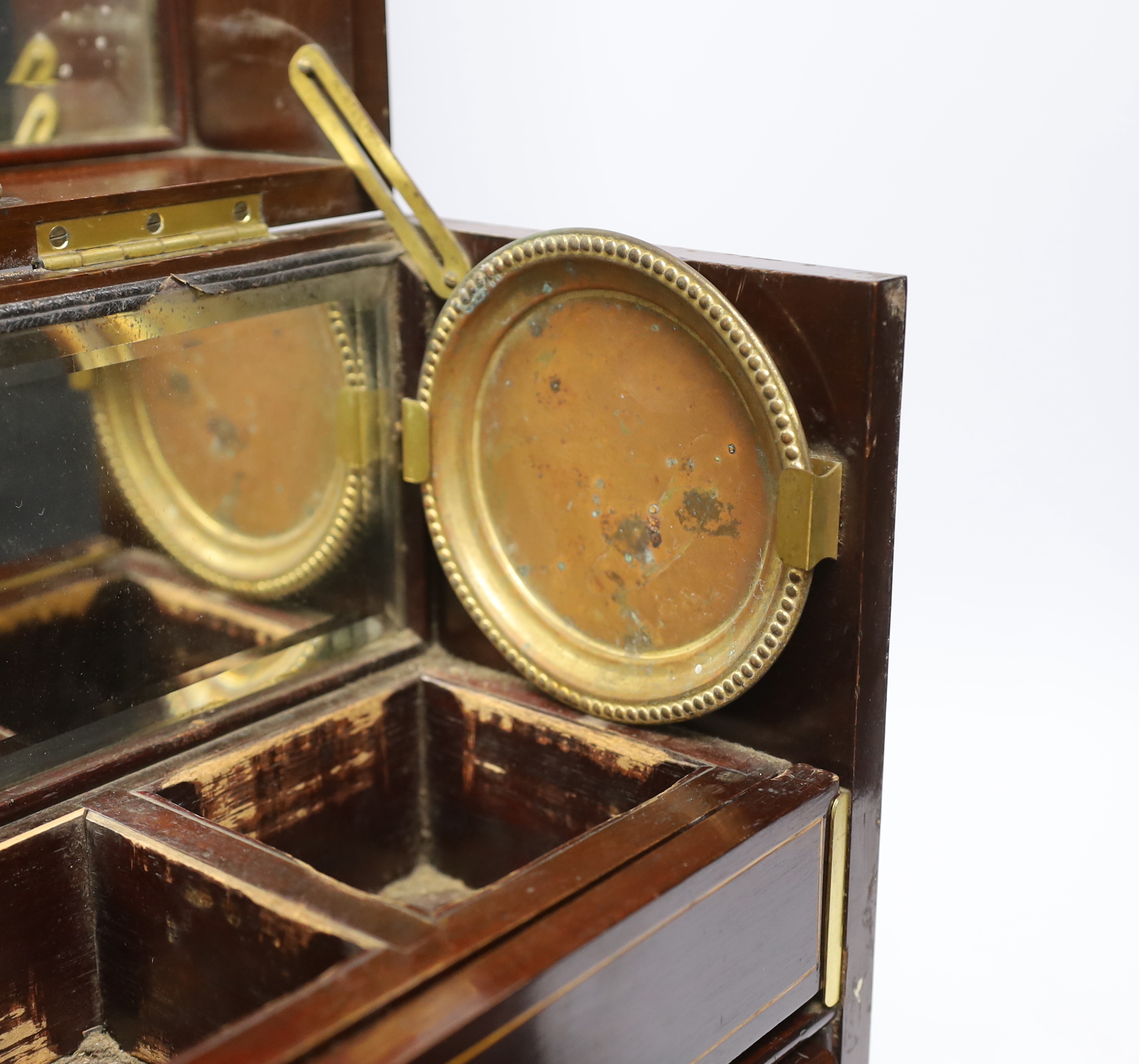 An Edwardian Sheraton revival inlaid mahogany portable drinks cabinet with tantalus and other accessories including serving trays, a brass cribbage board, with secret drawer, etc, 37cm high